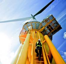 A yellow wind turbine viewed from below.