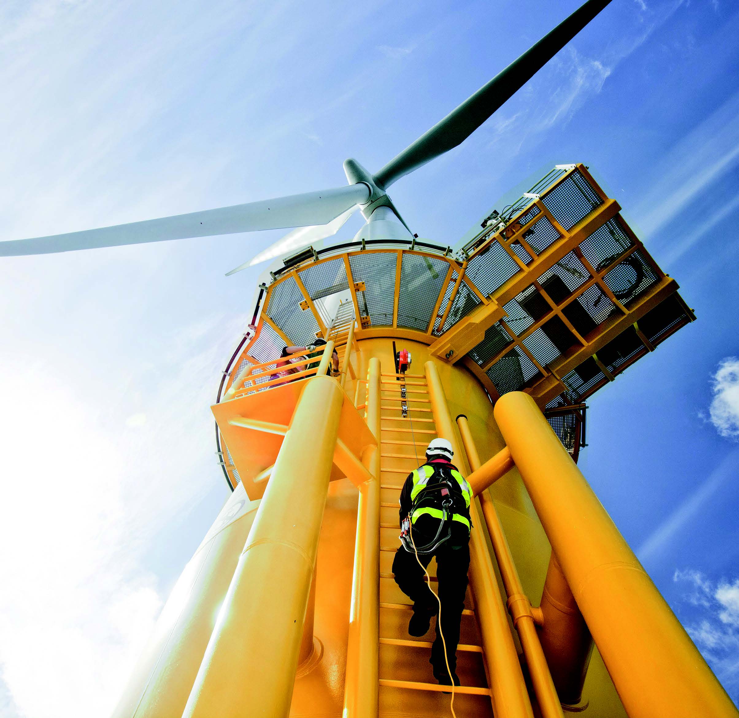 A yellow wind turbine viewed from below.